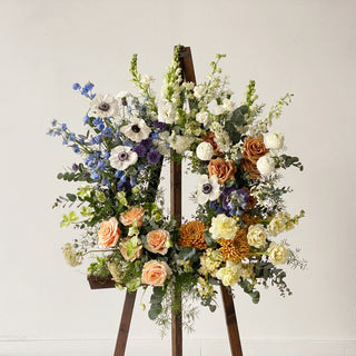 An upright floral wreath on an easel for a funeral