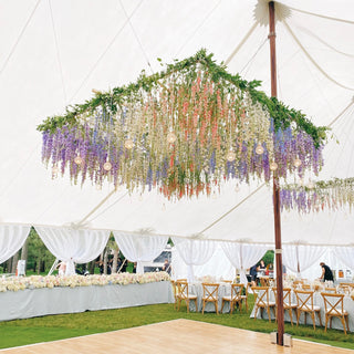 A large lavender, pink, and white floral statement hanging over the dancefloor in an outdoor tent
