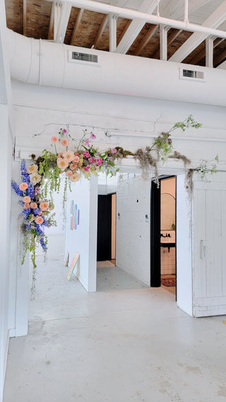 A floral statement draped around a doorframe in a white studio
