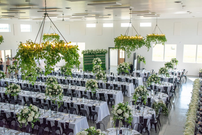 A large, garden-style floral statement piece sprawled across a fireplace mantel