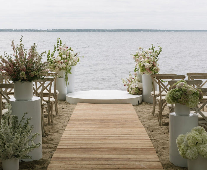 Aerial view of a lakeside wedding ceremony on the beach