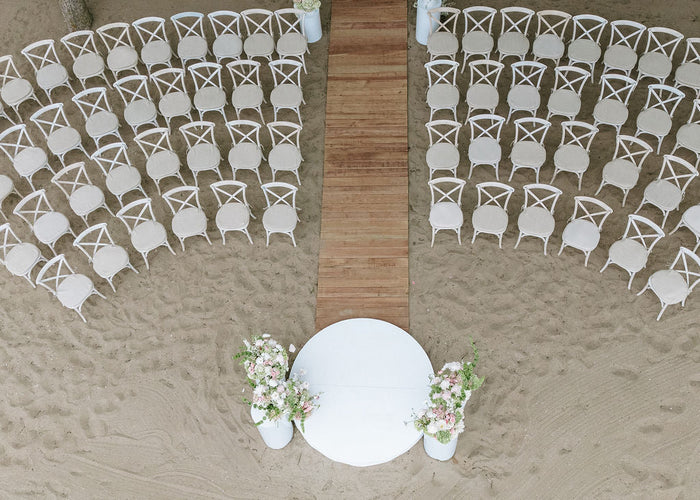 Aerial view of a lakeside wedding ceremony on the beach