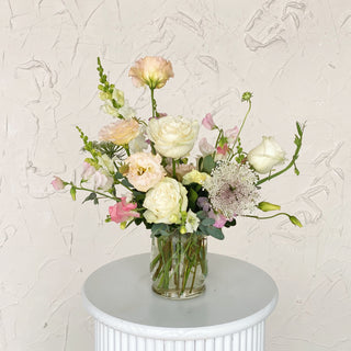 A floral arrangement filled with white and pastel pink flowers